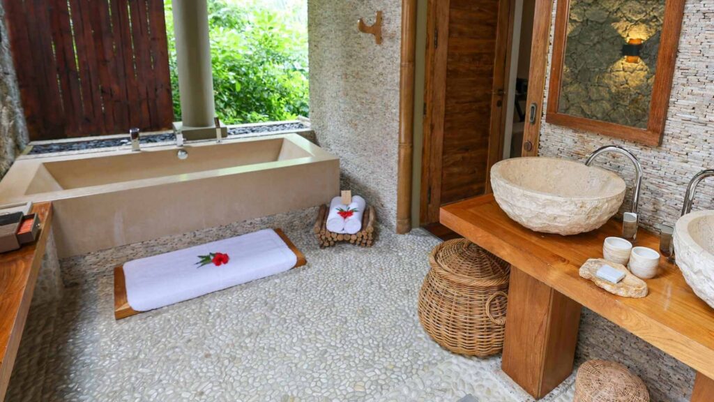 Bad i villa p&aring; Le Domaine de L&rsquo;Orangeraie. Naturmaterialer som stein og tre og badet har utsikt til naturen