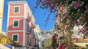 Fargerike bygninger og bougainvillea i en stemningsfull gate i Ibiza by nedenfor Dalt Vila.