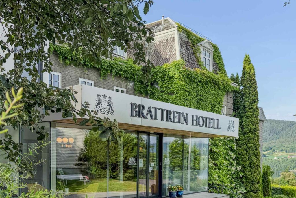 Fasaden til Brattrein Hotell i Notodden, et historisk hotell med utsikt over Heddalsvannet.