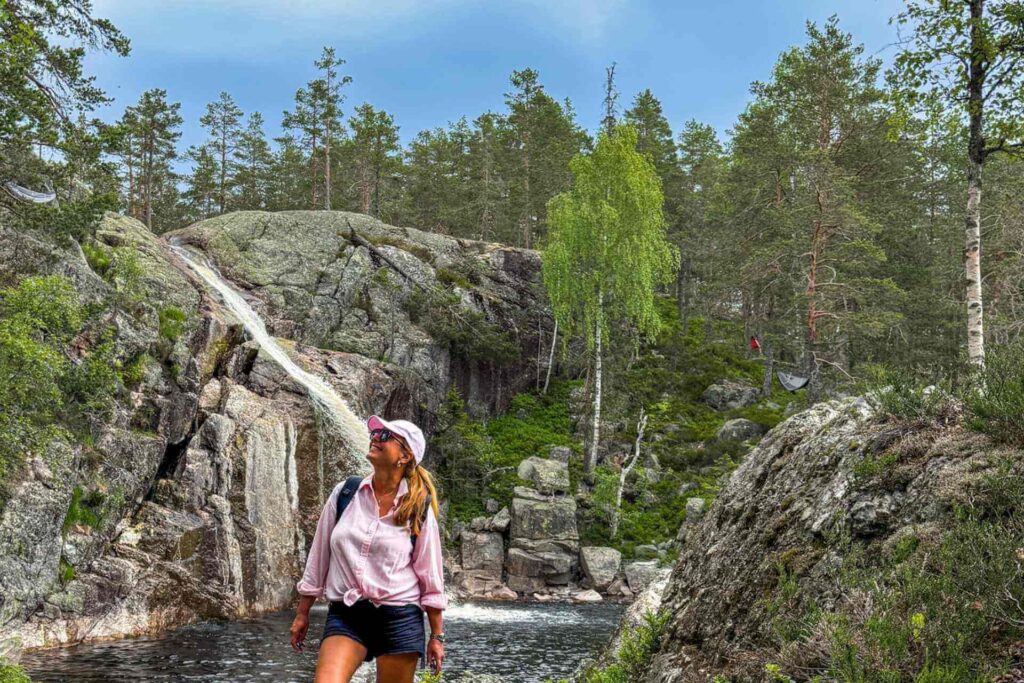 Vandrer, en dame, ved Dusanfossen i Notodden, et idyllisk fossefall omgitt av skog, svaberg og naturlige badekulper i Telemark.