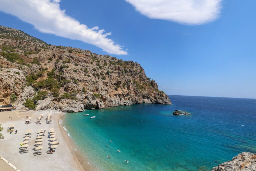 Achata Beach en av Karpathos' vakreste strender. Den lille bukten er omgitt av bratte klipper, og det krystallklare, turkise vannet gjør stranden perfekt for bading og snorkling. en avslappende stranddag.