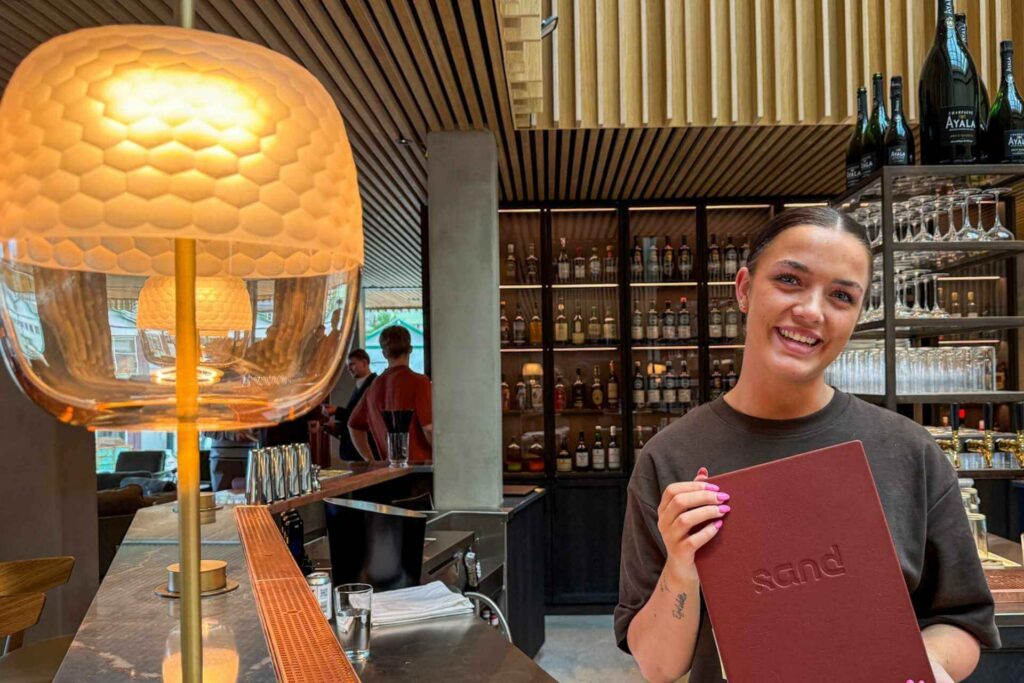 Baren p&aring; restauranten Sand p&aring; KG Hotel i Klaksv&iacute;k med smilende og blid ansatt. 