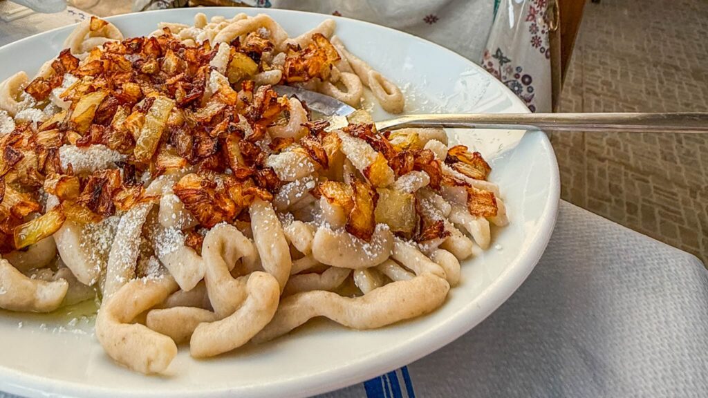 Makarounes, den tradisjonelle signaturretten fra Karpathos med hjemmelaget pasta, stekt løk og lokal ost.