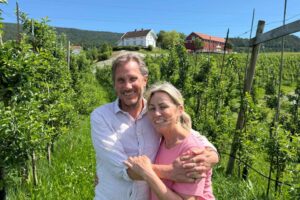 Grunderne bak NeRo sider på Hjukesbo med epletrar og garden i bakgrunnen