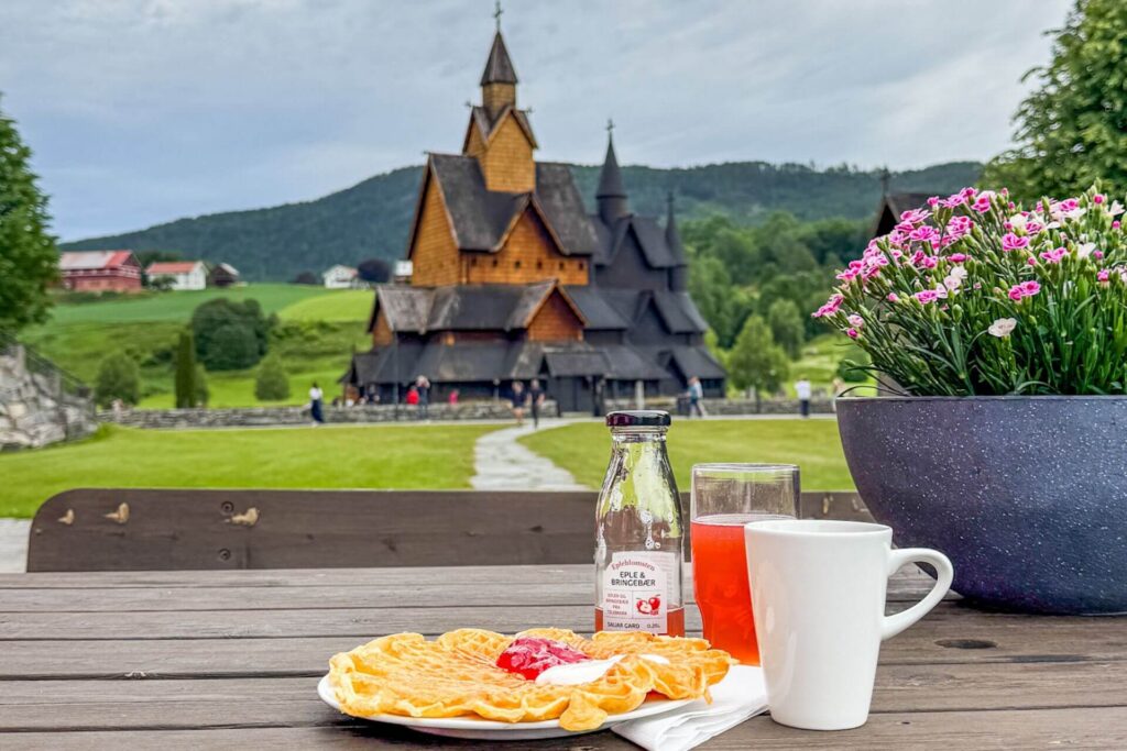 Nystekt vaffel og lokal epledrikk servert med utsikt mot Heddal stavkirke.