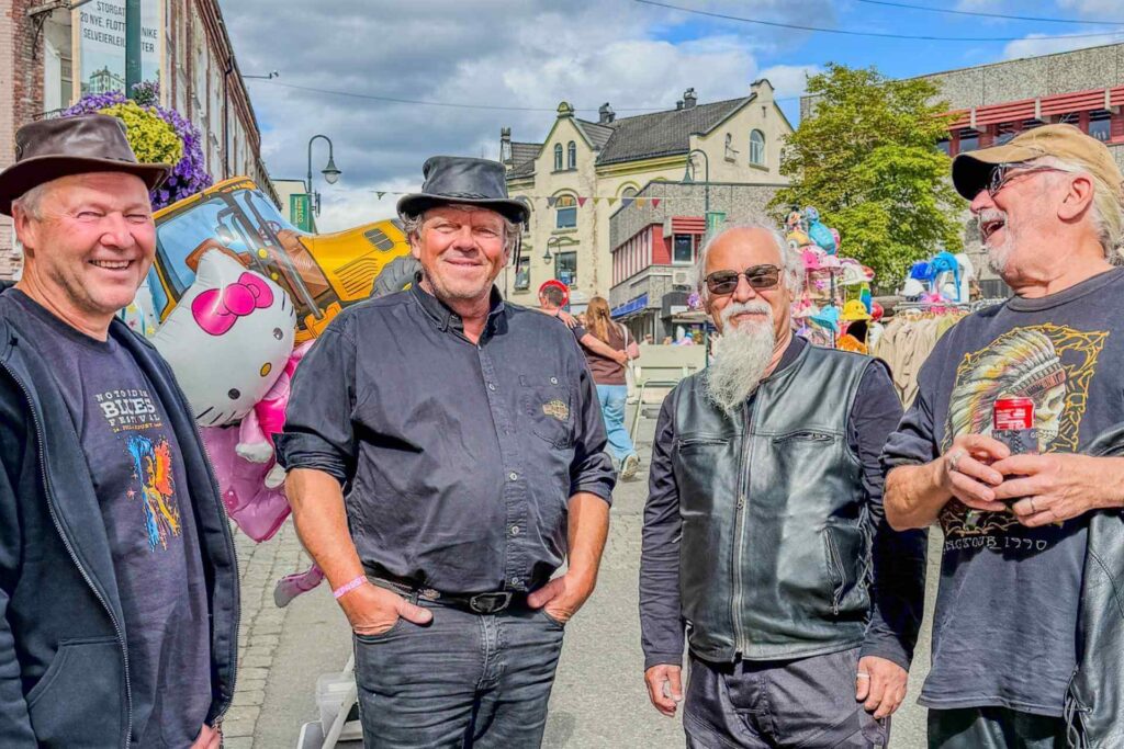 Festivalstemning i sentrum med fire smilende menn