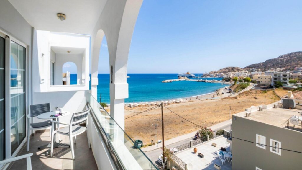 Balkong på Alos Suites i Pigadia på Karpathos, med utsikt over stranden, havet og havnen.