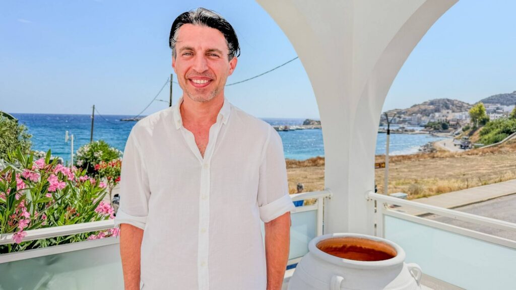 Vertskap og eier Elias Markis på Alos Suites står på hotellets terrasse med utsikt mot havet ved Pigadia.