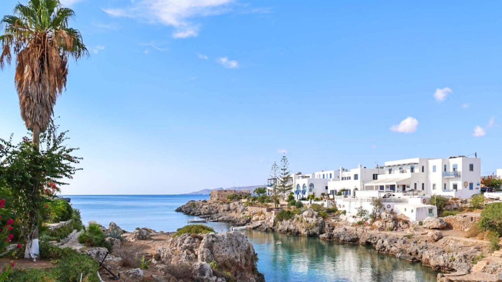 Avlemonas p&aring; Kythira med hvite hus, klipper og en naturlig badebukt med klart, turkist vann.