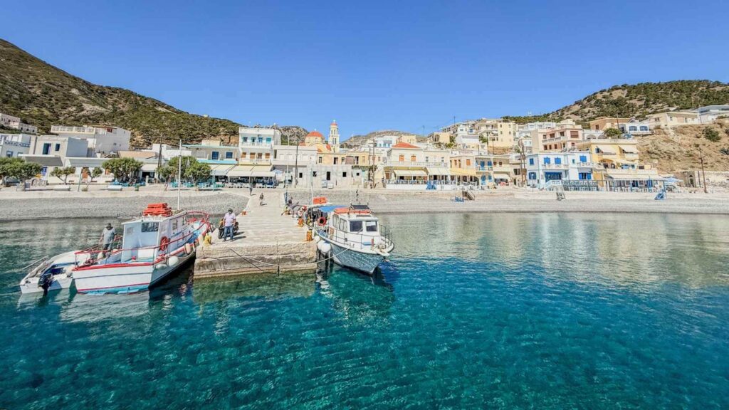Havnen i Diafani nord p&aring; Karpathos med fiskeb&aring;ter, turkist hav, hvite hus og fjell i bakgrunnen. Et sted hvor du b&oslash;r bo p&aring; Karpathos hvis du vil ha det rolig