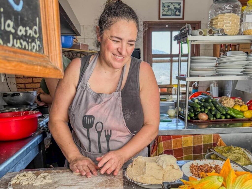 Kvinne lager tradisjonell h&aring;ndlaget makarounes-pasta p&aring; et kj&oslash;kken i Hellas.