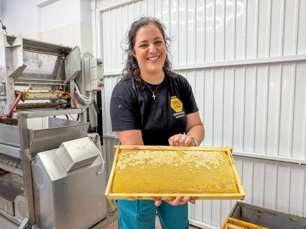 Lokal honningprodusent p&aring; Karpathos viser frem en ramme med honningkake fra bikuben.